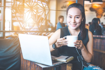 Business woman working in a coffee shop with a computer