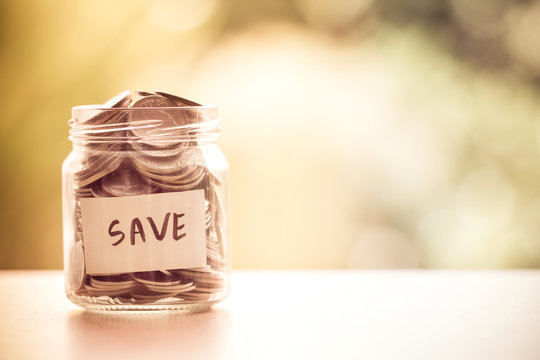 Coins in glass jar for money saving financial concept