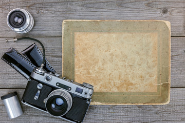 retro camera, negative film, lenses on wooden table background with copy space