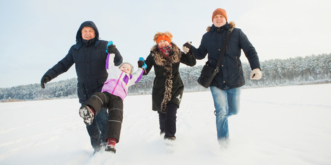 Grandparents, father and daughter, happy family hold arms and run together. Three generations have fun on a snowy winter day. Banner. Family values concept
