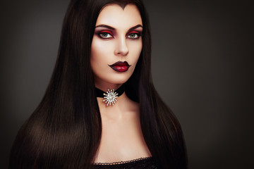 Halloween Vampire Woman portrait. Beautiful Glamour Fashion Sexy Vampire Lady with long dark Hair,...