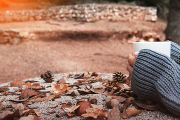 Holding a cup of coffee in autumn