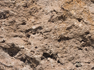 Old grey and brown rough stone wall, closeup texture background, selective focus, shallow DOF