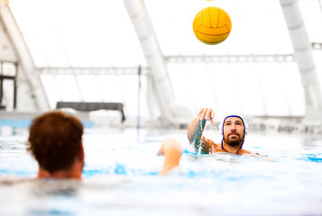Two water polo players in a swimming pool.