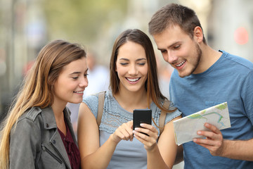 Three tourists checking location on the street - obrazy, fototapety, plakaty