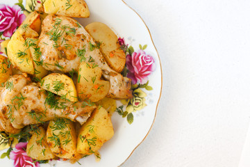 roasted chicken leg and potatoes on white plate .