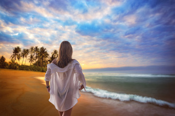 Fototapeta na wymiar Woman on the beach at sunset in Asia