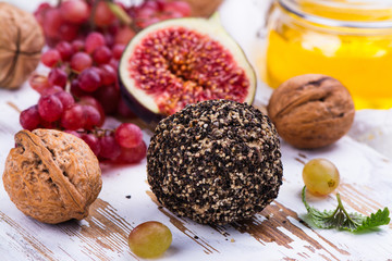 Goat cheese with spices and snacks on white wooden board
