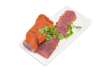 Partly sliced cured pork tenderloin on white dish