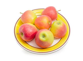 Red and yellow apples on a dish
