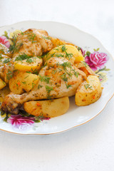 roasted chicken leg with boiled potatoes on white plate