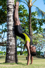 Young yoga man practitioners doing yoga on nature. Asian indian yogis man on the grass in the park. Bali island.