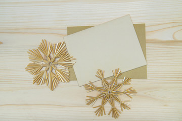 Top view of  blank christmas card with handmade snowflakes on a wooden background. Christmas background in natural tones.