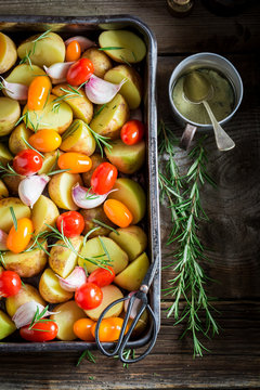 Preparation for grilled tasty potato with garlic, rosemary and tomatoes
