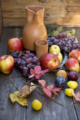 Apples fruit autumn yellow red leaves jug grapes vitamins wooden table still life