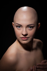 Portrait of a bald girl on a black background.