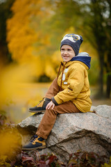 Cute little kid boy on autumn day. Preschool child in colorful autumnal clothes