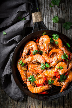 Tasty shrimps on pan with garlic, coriander and peppers