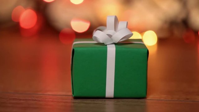 Dolly shot of present box against blurry lights - small gift for christmas or other events
