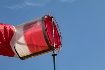 Airport windsock on clear blue sky background in windy weather indicate the local wind...