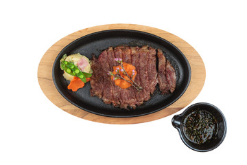 Isolated top view of medium rare wagyu steak topping with mince carrot on hot plate and wooden plate served with potato salad with ponzu sauce.