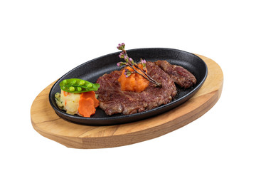 Isolated medium rare wagyu steak topping with mince carrot on hot plate and wooden plate served with potato salad.