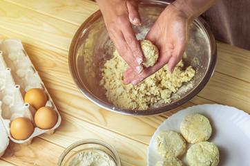 Preparation of raw dough cottage cheese pancakes. Cheesecakes in the hands of the cook.