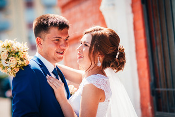 Bride and groom embracing on city background