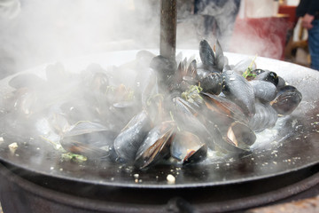 Preparation of mussels. Mussels in a frying pan. Street food.
