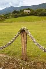 vintage limitation of the territory. a wooden pole with a thick old sea rope.