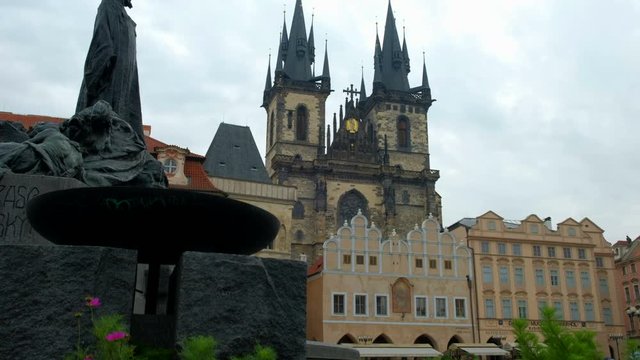 Camera rises to reveal an Hus Monument with the church of our lady behind. Prague
