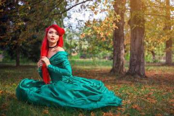 Cute girl in a beautiful dress in an autumn forest. Character of a mermaid at the cosplay festival - obrazy, fototapety, plakaty