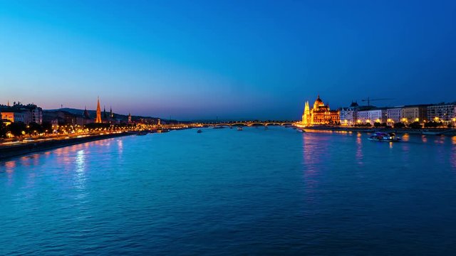 Budapest, Hungary. Illuminated Parliament building in Budapest, Hungary at sunset. Time-lapse at night with boats