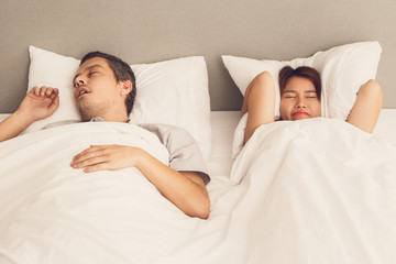 Angry Asian woman annoyed with husbands snoring