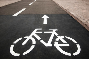 Fototapeta premium Bicycle white sign or icon on the asphalt road in the city