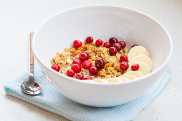 Muesli with banana and berries for breakfast.