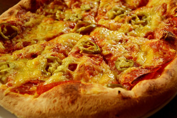 whole italian pizza on wood table with ingredients