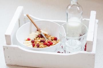 Muesli with banana and berries for breakfast.