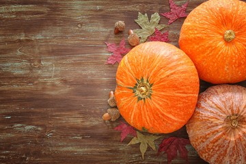 Pumpkins and autumn leaves on wooden background. thanksgiving and halloween concept