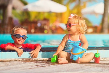 little boy and girl playing in swimming pool at beach