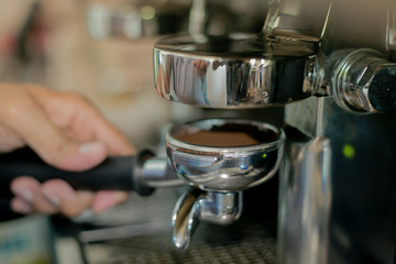 Close up barista hands making coffee by machine in coffee cafe.