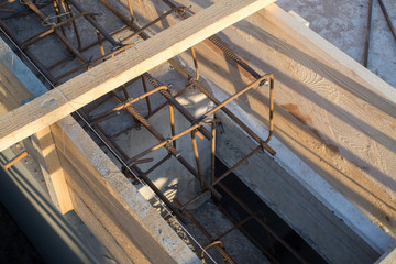 Foundation site of new building, details and reinforcements with steel bars and wire rod in wooden decking, preparing for cement pouring