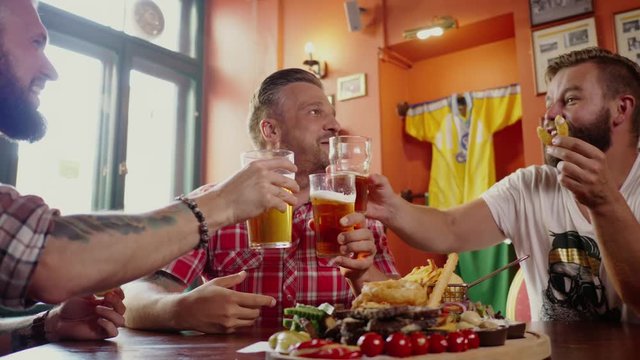 Good old friends drinking beer in a pub