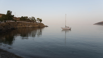 Reflet d'un voilier dans l'eau dans une baie