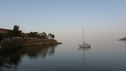 Fototapeta premium Reflet d'un voilier dans l'eau dans une baie