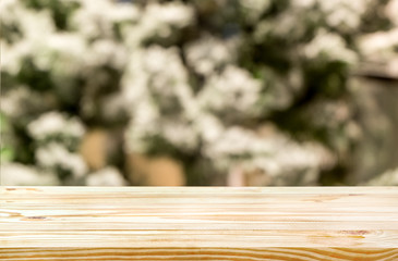 Christmas holiday background with empty wooden deck table over christmas tree with snow. Ready for product montage. xmas background.