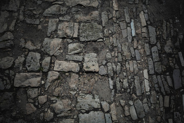 stone pavement. Old road paved with stones. Background, texture of stones and boulders. Dark style