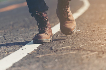 young man looking for freedom lifestyle ; man walking on the road to travel in countryside 