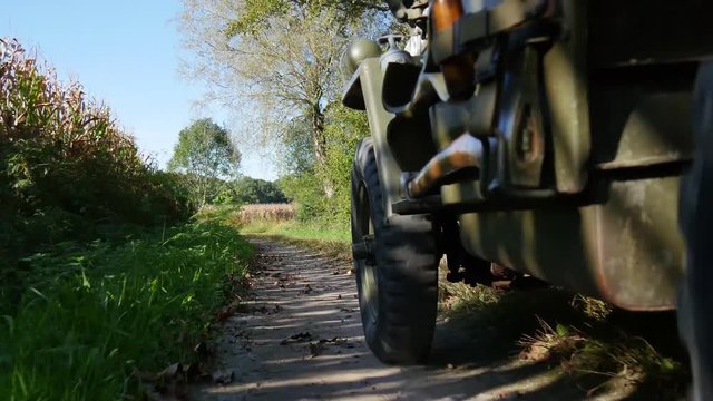 military jeep 4x4 car driving on dirt road, close up of wheel