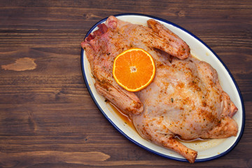 raw duck with spices and orange on white dish